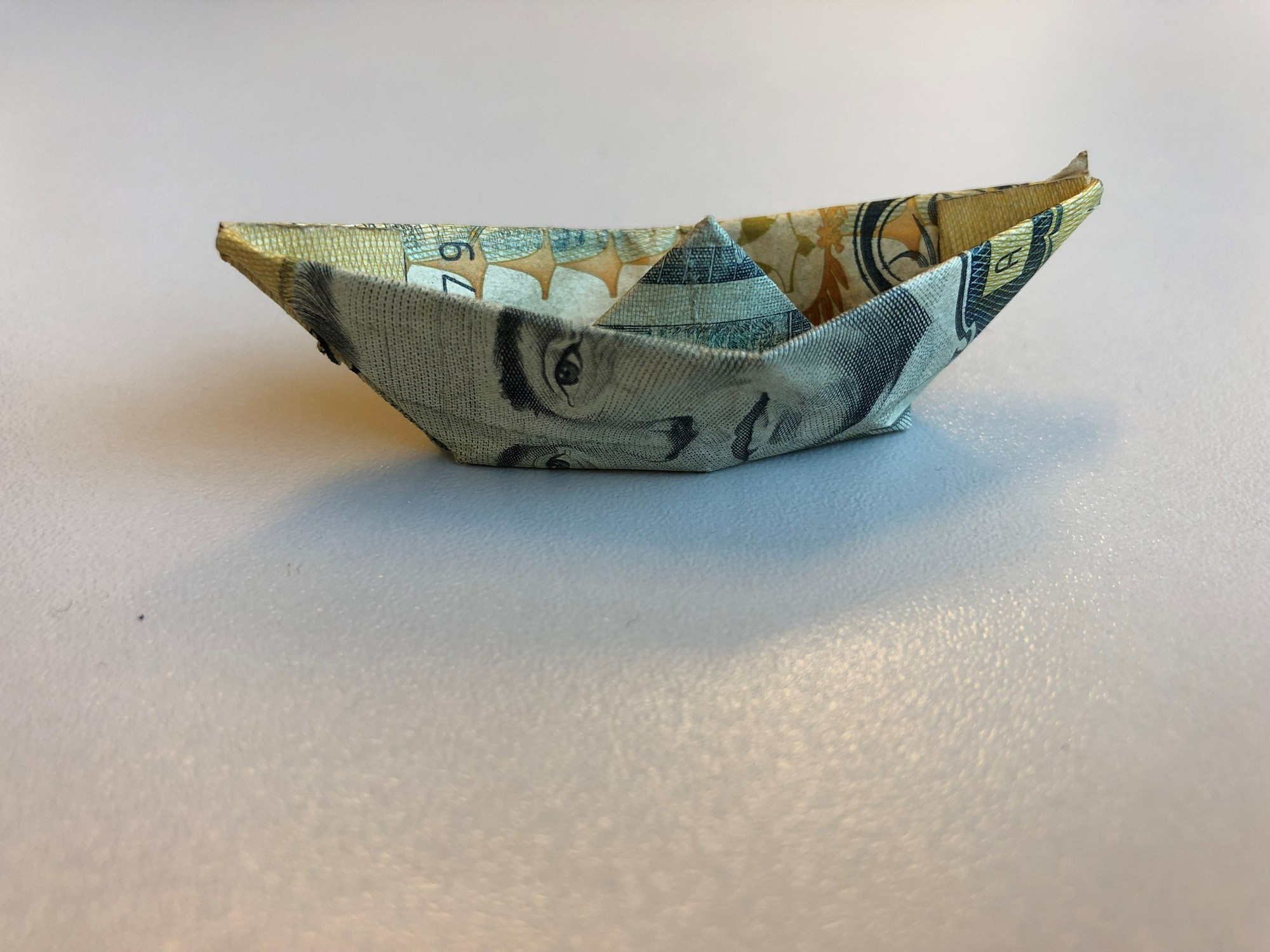 Image of a little handmade boat done with a paper bill